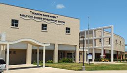 The outside of the ECDC, a 2-story white brick school building