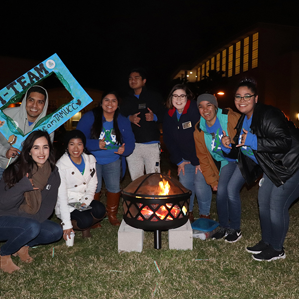 Students gather around a bondfire for I-Team's event at night