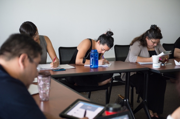 people writing at a table