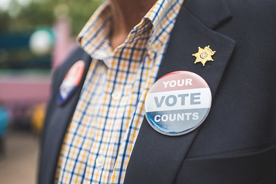 Man wearing blue coat with Vote sticker