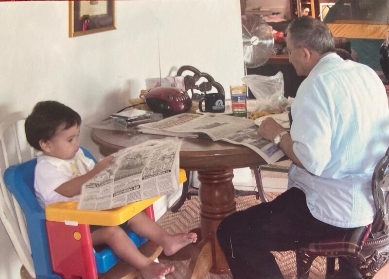 Arturo Vasquez, and grandson Gabriel, reading the newspaper. 