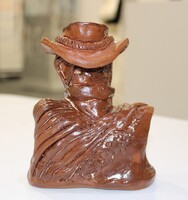 Ceramic bust of a figure with a cowboy hat and bandana.
