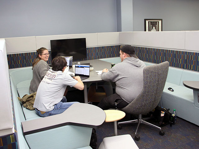 Study booths for groups with bench seating, table, and TV monitor.
