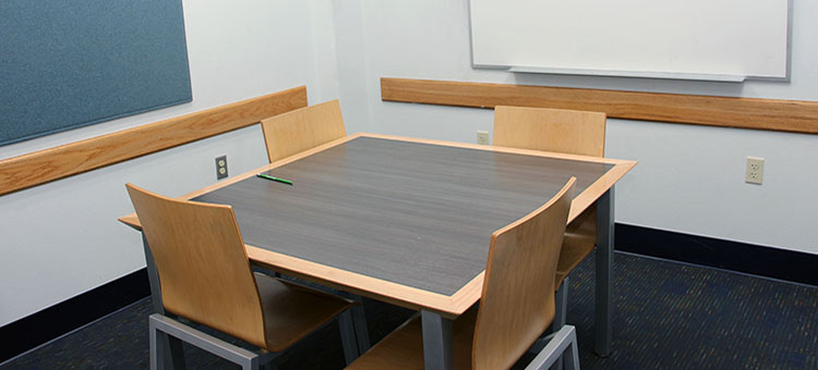 Small group study room with one white board, one table, and four chairs