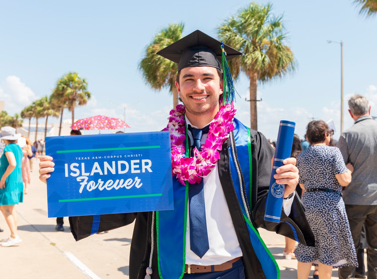 Islander+graduate+holding+an+Islander+Forever+sign