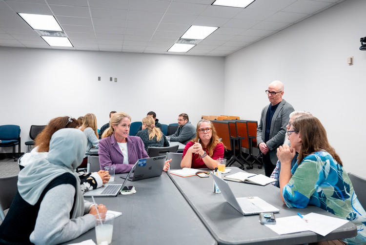 Dr.+Chris+Benedetti+leads+a+discussion+during+a+meeting+of+an+AI-forward+Community+of+Practice