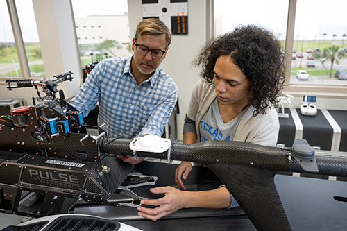 Computer science student and professor working on a drone