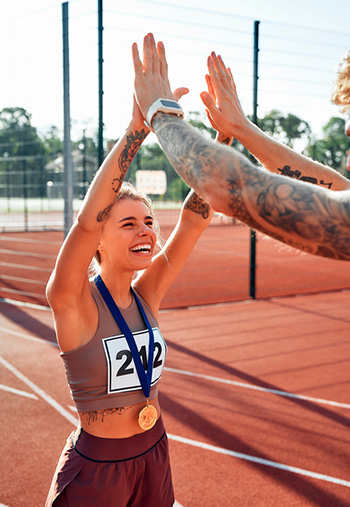 Female track runner giving a high five after a race