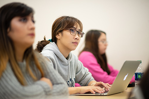 Communications students listening to a lecture in a classroom setting