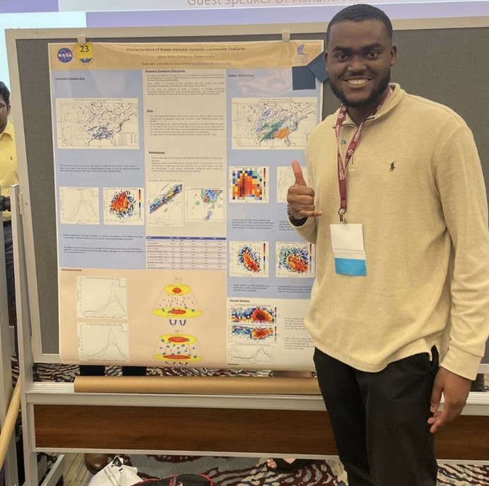 Quincy Walker standing next to scientific poster