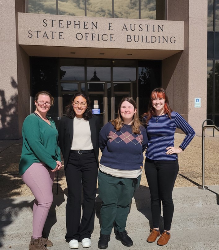 Four students in front of Stephen A. Austin State Office Building