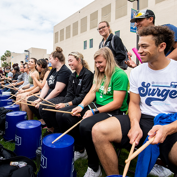 Students gather for drum circle and play drums