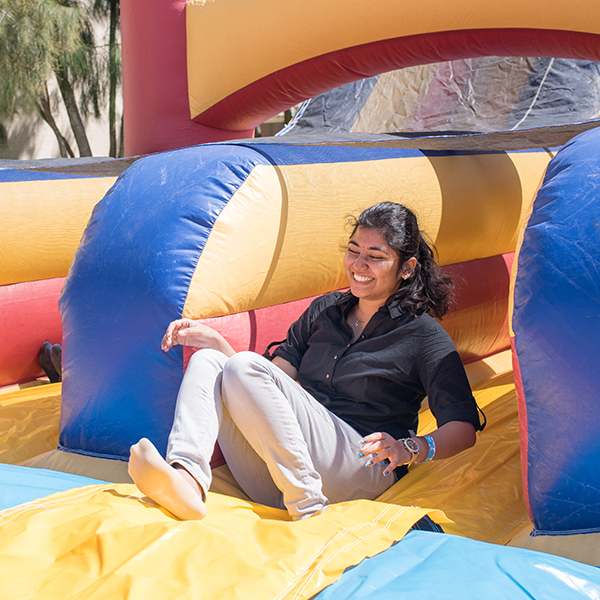 Girl is smiling as she reaches the bottom of an inflatable bouncy house obstacle course