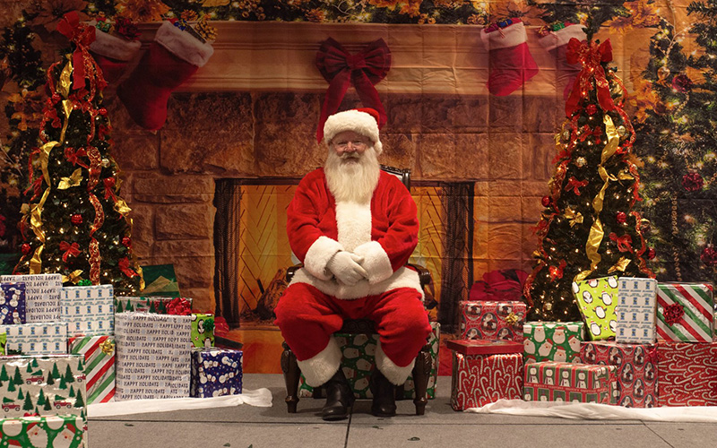 Santa sitting near a fireplace